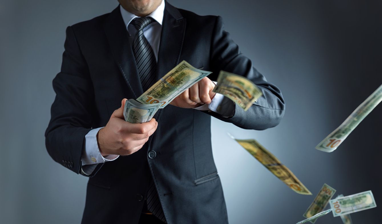 Businessman throwing dollar banknotes in air